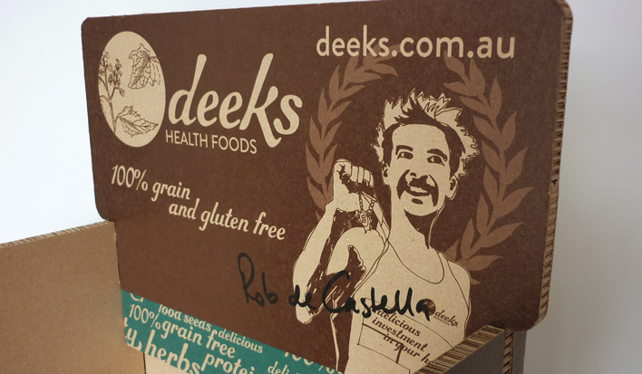 The headboard for Deeks Health Foods bread display stand using the Deeks logo, an illustration of founder Rob de Castella and his signature across the front.